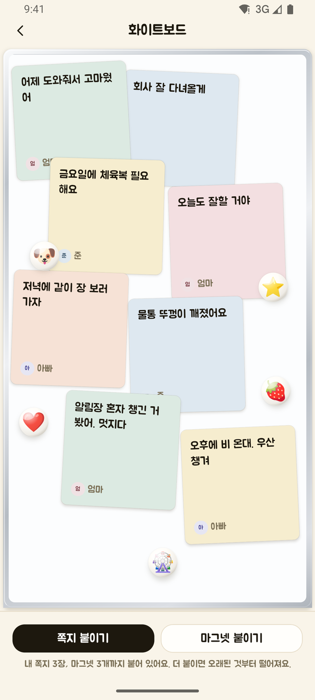 끄덕 앱의 화이트보드 화면. 알루미늄 틀을 두른 흰 판에 색이 다른 쪽지 여덟 장이 서로 겹쳐 기울어진 채 붙어 있다. 엄마가 붙인 「어제 도와줘서 고마웠어」 「오늘도 잘할 거야」 「알림장 혼자 챙긴 거 봤어. 멋지다」, 아빠가 붙인 「회사 잘 다녀올게」 「저녁에 같이 장 보러 가자」 「오후에 비 온대. 우산 챙겨」, 준이 붙인 「금요일에 체육복 필요해요」 「물통 뚜껑이 깨졌어요」가 보인다. 그 위에 별·강아지·딸기·하트·관람차 모양의 이모지 자석 다섯 개가 얹혀 있고, 아래에 쪽지 붙이기와 마그넷 붙이기 버튼이 있다.